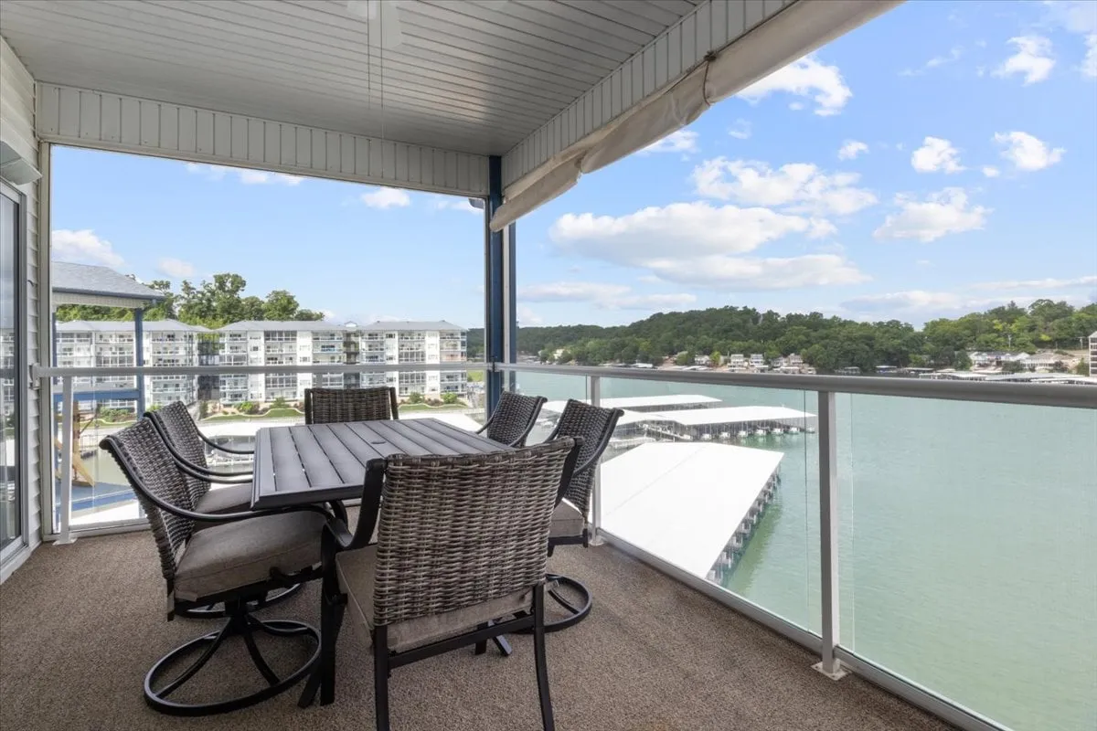 An exterior shot of an outdoor dining area with comfortable seating, set beside a picturesque lakefront. It’s perfect for al fresco breakfasts, sunset dinners, or simply enjoying the serene water views. The scene conveys relaxation and connection with nature, with the water and sky creating a peaceful backdrop.